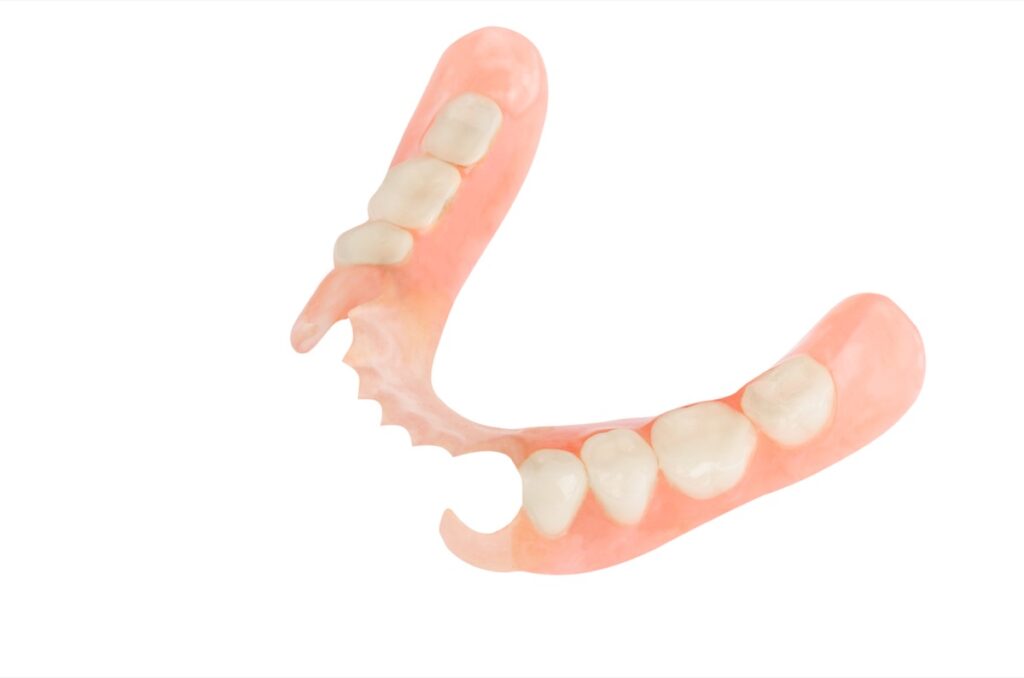 Removable plastic partial denture on white background